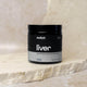 Black container labeled 'switch liver' on a stone surface.