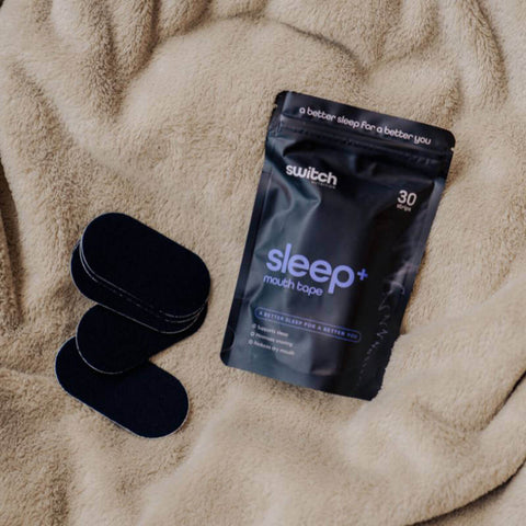 Sleep mouth tape packaging with three tapes on a beige blanket.