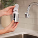 Person holding detached filter section of tap and showing how to add refills.