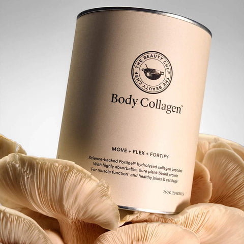 Body Collagen container sitting on top of mushrooms on a grey background.