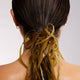Person with seaweed in their hair against a plain background.