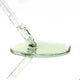 Glass dropper with green liquid on a white background