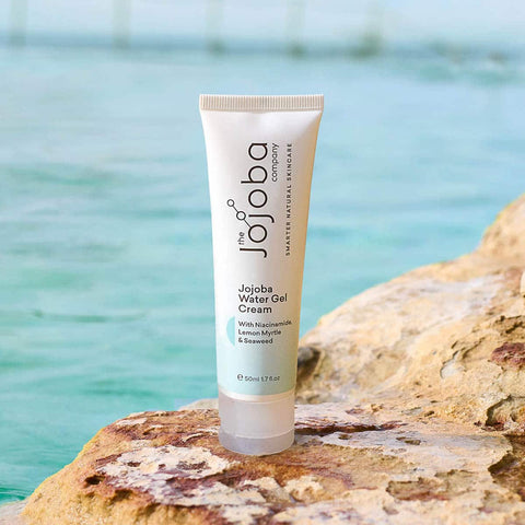 Tube of Jojoba Water Gel Cream on a rock with a blurred natural background