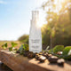 Spray bottle labeled 'The Jojoba Company' Toning Mist on a wooden surface with leaves and coffee beans.