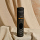 Black cylindrical packaging with 'Three Warriors' branding on a beige fabric background.