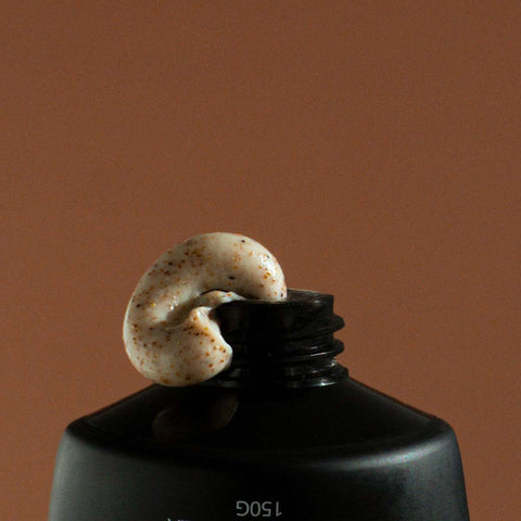 Sand scrub being squeezed out of tube set against a brown background.