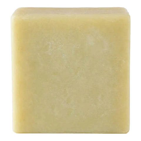A single square bar of pale yellow soap with a textured surface, isolated on a white background.
