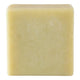 A single square bar of pale yellow soap with a textured surface, isolated on a white background.