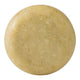 A round, solid bar of soap with a textured surface in a light tan colour, isolated on a white background.