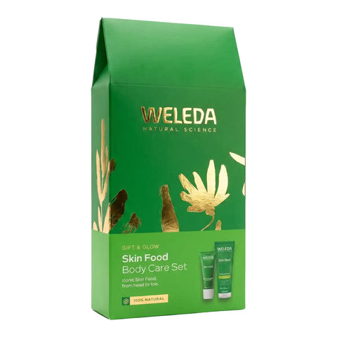Weleda Gift and Glow Skin Food Body Care Set in a green gift bag with gold foil botanical designs, shown on a plain white background.