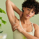 Woman wearing a beige tank top against a light green background