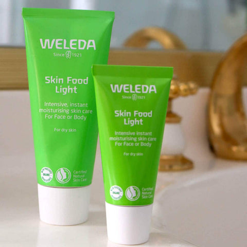 Two green Weleda Skin Food Light tubes on a blurred background